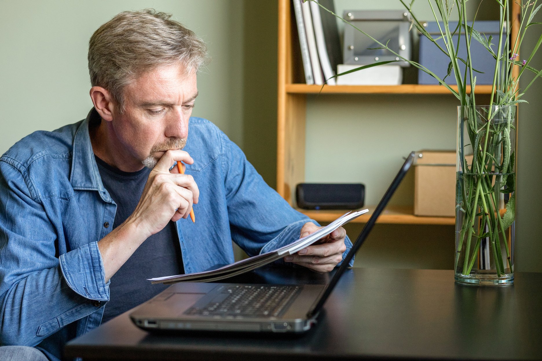 50 year old bearded man working at home office